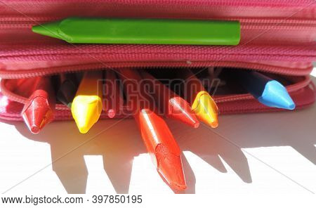 Colored Wax Crayons Stick Out From A Pink Pencil Case