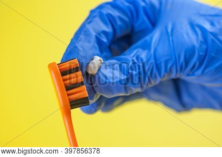 Tooth brush and deciduous milk child teeth on yellow background