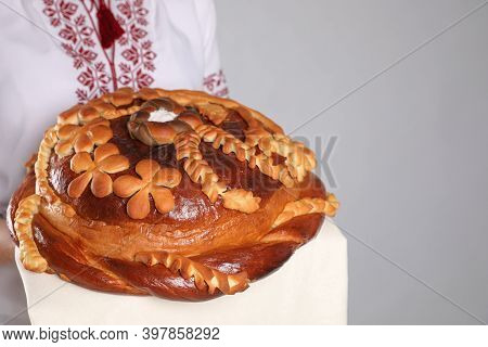 Woman Holding Korovai On Grey Background, Closeup With Space For Text. Ukrainian Bread And Salt Welc
