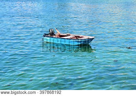 Portosin, Spain. July 3, 2020. Old Red And Blue Wooden Small Boat Floating On The Sea At Famous Rias