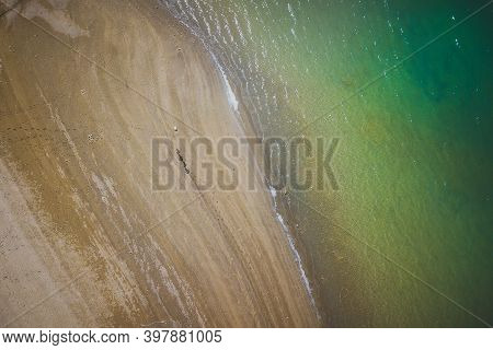 Shore Of A Lake With People Walking Near It And Very Bright Colors