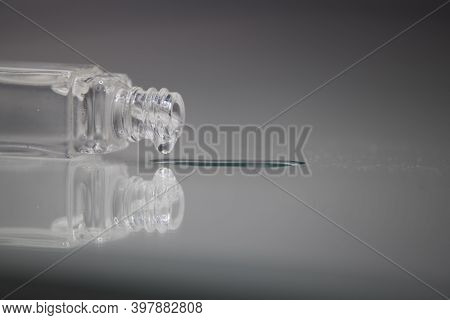 Glass Bottle With Spilled Perfume And Reflection In The Glass