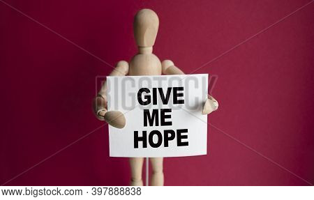 The Wooden Man Holds A White Sign With The Text Give Me Hope In His Hands. The Content Of The Letter