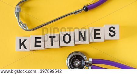 Ketones - Word On Wooden Cubes On Yellow Background With Stethoscope.