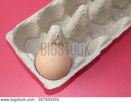 Beige Boiled Eggs In A Pot Of Water With An Egg Box On A Gray Background. High Quality Photo