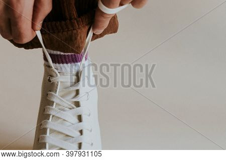 Model hands tying shoelaces white sneaker