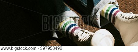 Legs in high top white sneakers on jeans model banner
