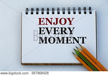 Enjoy Every Moment - Words On A White Notepad And Pencils. Success And Positive Concept