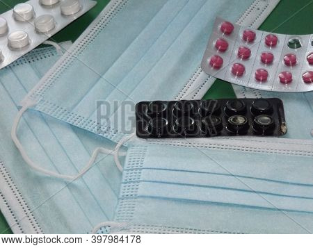 Light Blue Medical Masks And Colorful Covid 19 Pills. High Quality Photo