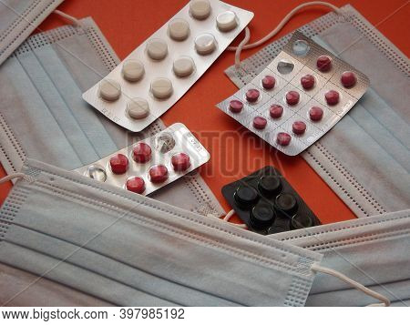 Light Blue Medical Masks And Colorful Covid 19 Pills. High Quality Photo