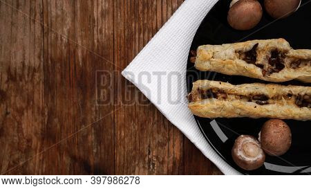 Rollini Delicious Pastries With Mushrooms, Champignons And Cheese On A Black Plate On Wooden Backgro