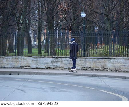 Young Man In A Coat On A Skateboard, Tsaritsynsky Proezd, Saint Petersburg, Russia, December 2020