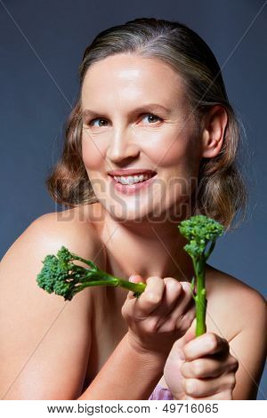 mooie veertig jaar oude vrouw met natuurlijke make-up en gezonde huidtextuur op blauw grijs studio bac