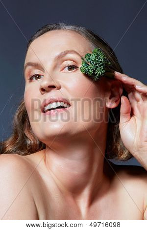 mooie veertig jaar oude vrouw met natuurlijke make-up en gezonde huidtextuur op blauw grijs studio bac