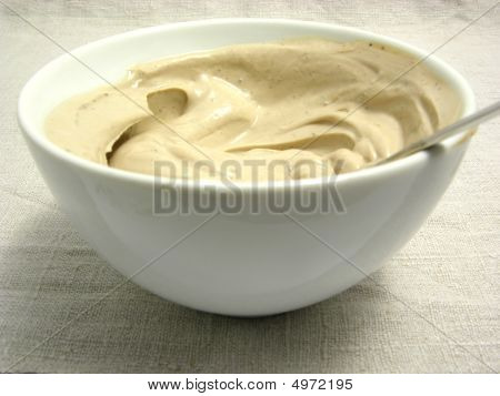 Quark formaggio miscelato come Dip In una ciotola di porcellana su una tovaglietta