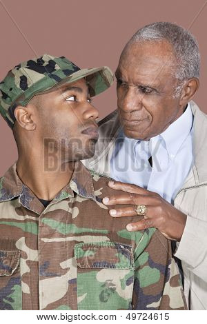 Father and US Marine Corps soldier looking at each other over brown background