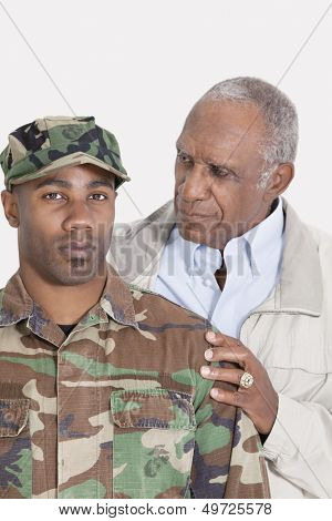 Portrait of an African American US Marine Corps soldier with father over gray background