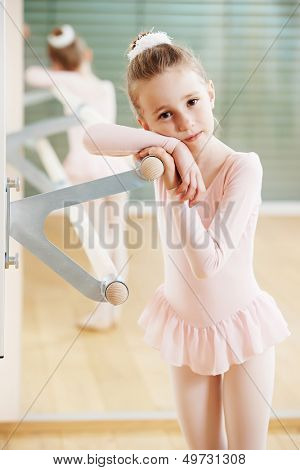 Little girl in ballet suit at training exercise in front of mirror
