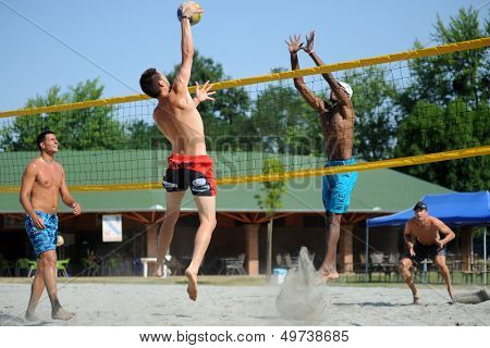 KAPOSVAR, HUNGARY - AUGUST 4: Tamas Kaszap (with ball) in action at a ROAK Viragfurdo Kupa beach volleyball competition, August 4, 2013 in Kaposvar, Hungary.