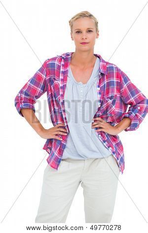 Serious blonde standing with her hands on her hips on white background