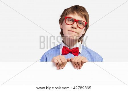 School boy in red glasses holding white square