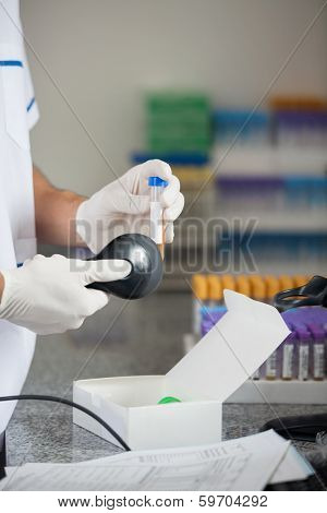 Cropped image of male technician scanning barcode on medical sample in laboratory