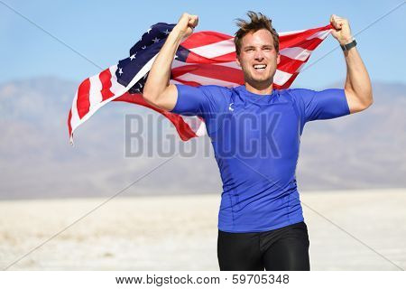 Success - winning runner cheering with USA flag celebrating victory. Fit American male winner fitness running model in celebration of success win. Face expression showing successful achievement.