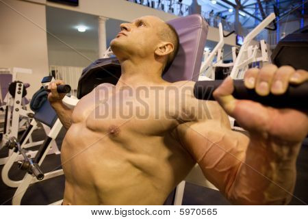 Bodybuilder ด้านข้างทำการยกน้ำหนักในโรงยิม