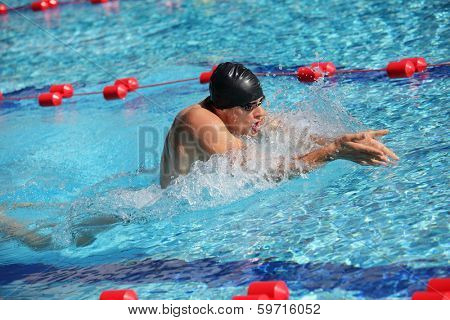 Swimmer in cap breathing performing the breaststroke - right profile
