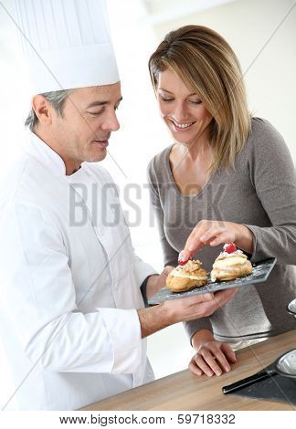 Pastry cook having woman tasting pastries