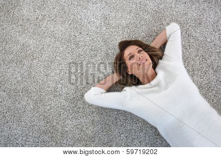 Upper view of woman relaxing on carpet at home