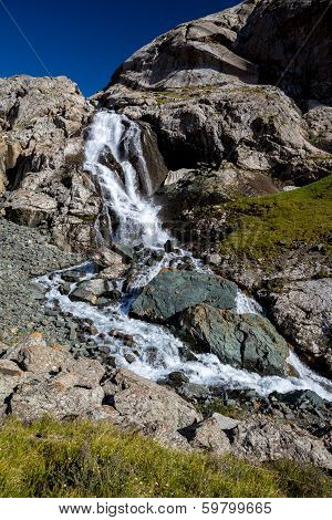 Waterfall flowing from Ala-Kul lake. Kyrgyzstan