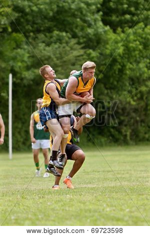 Player Jumps To Catch Ball In Australian Rules Football Game