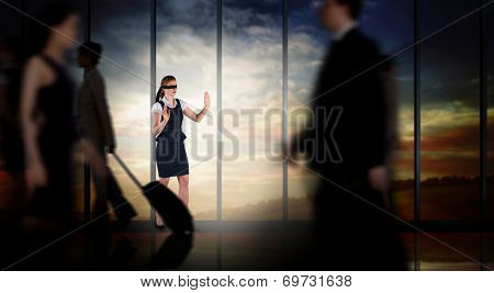 Redhead businesswoman in a blindfold against room with large window looking on landscape