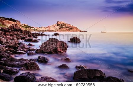 Ocean Coastline With Village In The Background At Sunrise