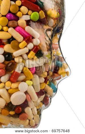 a head made of glass filled with many tablets. photo icon for drugs, abuse and addiction tablets.