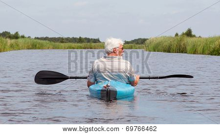 Man Paddling In A Blue Kayak