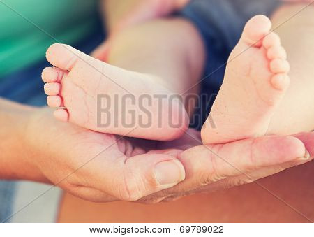 Mother holding adorable newborn baby feet
