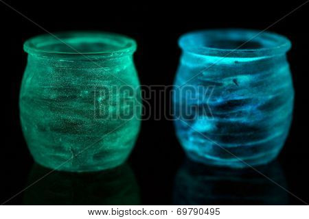 Candlesticks painted fluorescent paint isolated on black