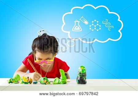 Little girl with a pencil thinking about Science and writing something on table.