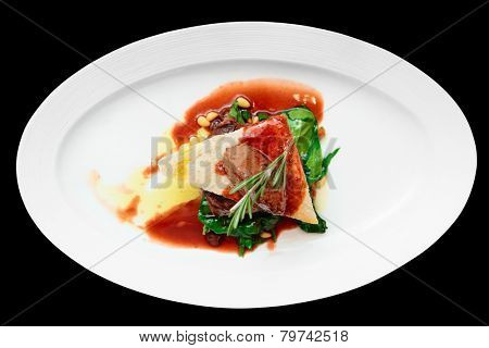 Tenderloin steak with beef terrine and spinach isolated on black