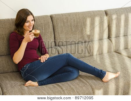 Beautiful woman at home drinking a capuchino