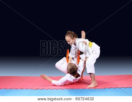 Girl and boy are trained judo throw on the mat