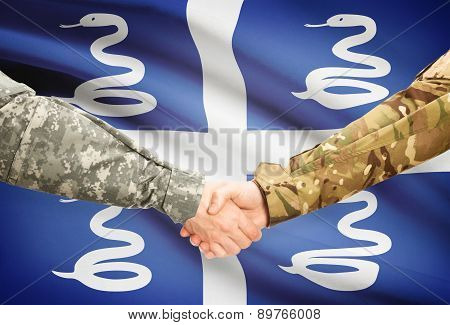 Men In Uniform Shaking Hands With Flag On Background - Martinique