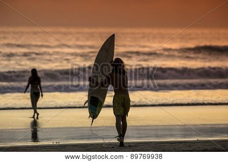 Surfer On The Beach At Sunset Tme