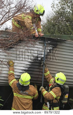 Fire fighters supporting colleague on roof