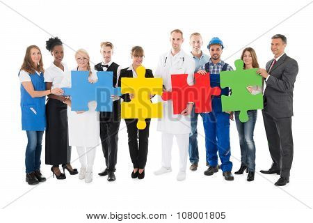 Confident People With Various Occupations Holding Jigsaw Pieces