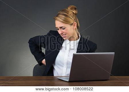 Businesswoman Suffering From Backpain While Using Laptop