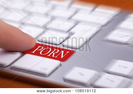 Finger Pressing On Red Button With Porn Word On It And Blurred Background