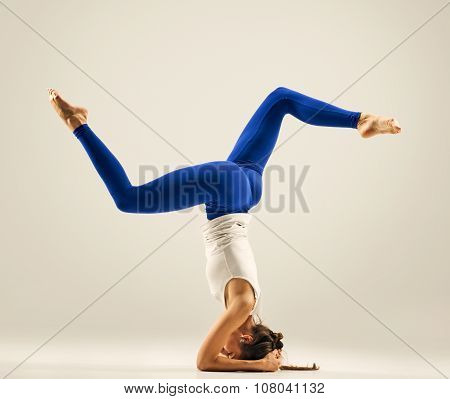 Young woman doing yoga Headstand Pose